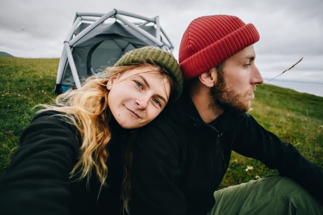 a couple is camping together and taking a selfie