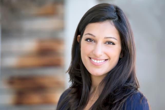 a young dark-haired woman is smiling
