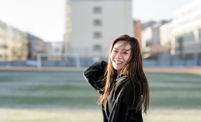 a young asian girl smiling outdoors