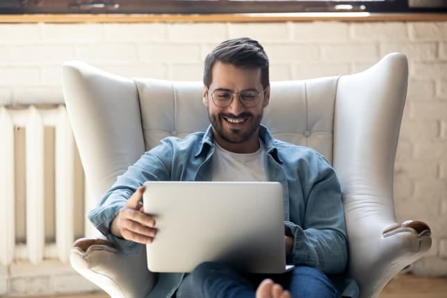 a man using his laptop while smiling