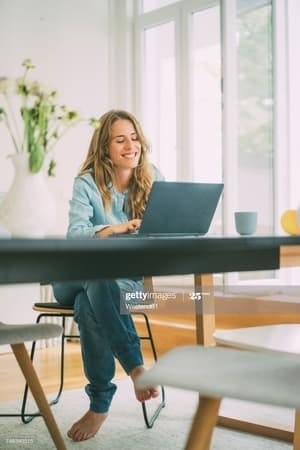 a young blonde woman working on her laptop in office