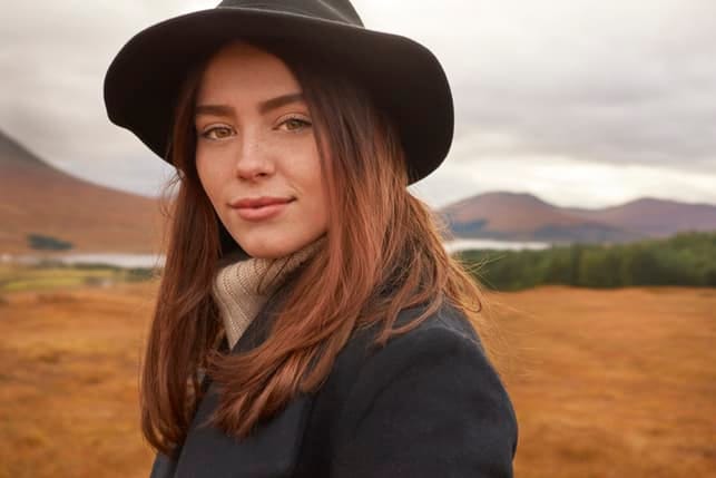 a portrait of a young woman wearing a hat
