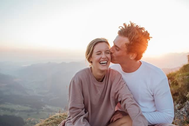 a young happy couple kissing outdoors