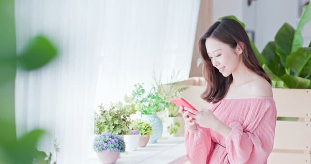 a beautiful asian woman is checking her phone