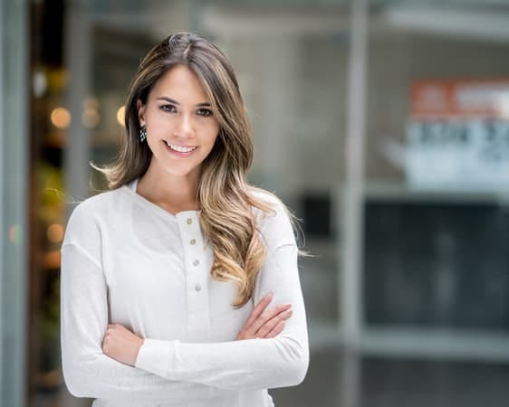a woman in white blouse is posing with her arms crossed in the business centre