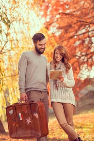 a couple walking through an autumn park