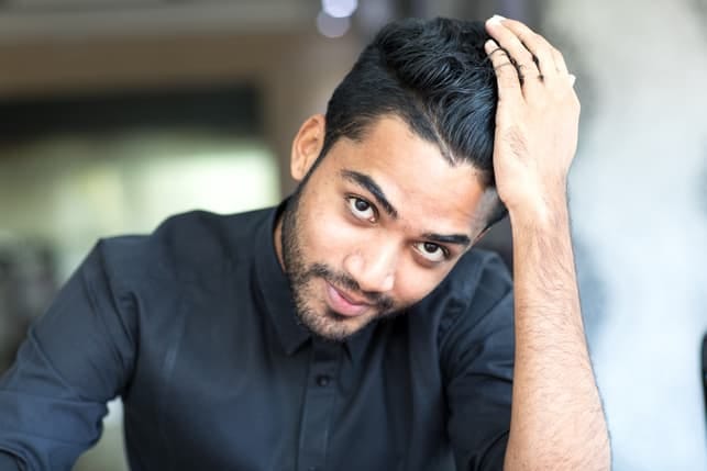 a portrait of a handsome Indian man wearing a black shirt