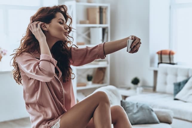 a curly woman taking a selfie