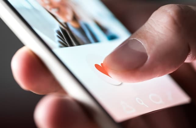 a hand of a person using a dating app on their smartphone