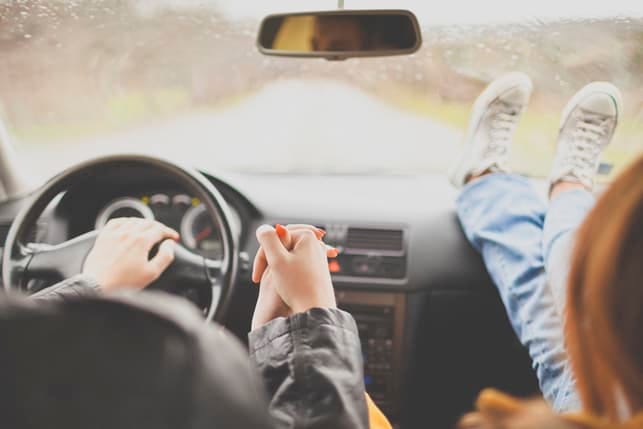 a couple holding hands while driving