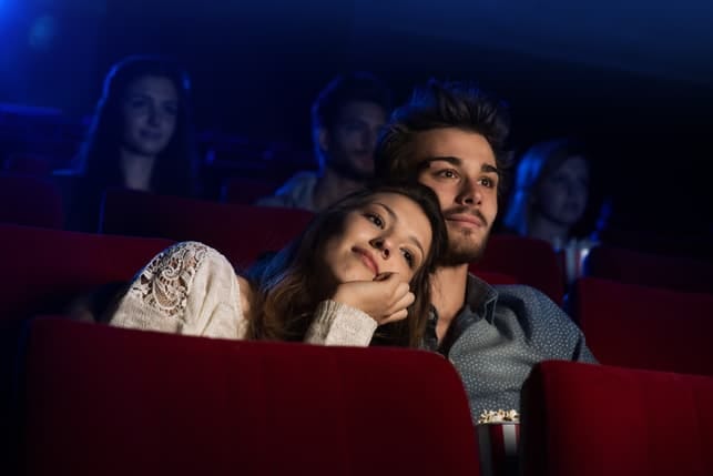 a couple watching a movie at the cinema on a date