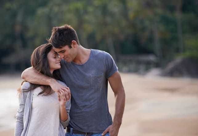 a young couple walking on a beach