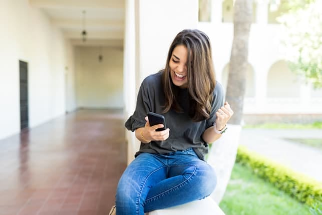 a woman is checking her phone while smiling