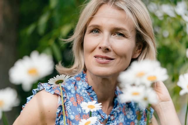 Lovely woman surrounded by the chamomiles