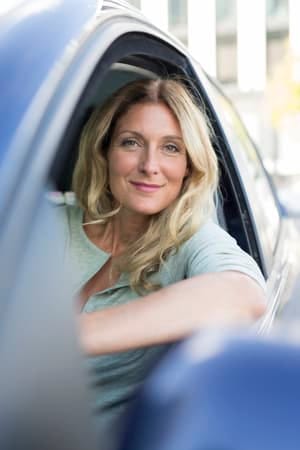 a portrait of an attractive blonde woman over 40 driving a car
